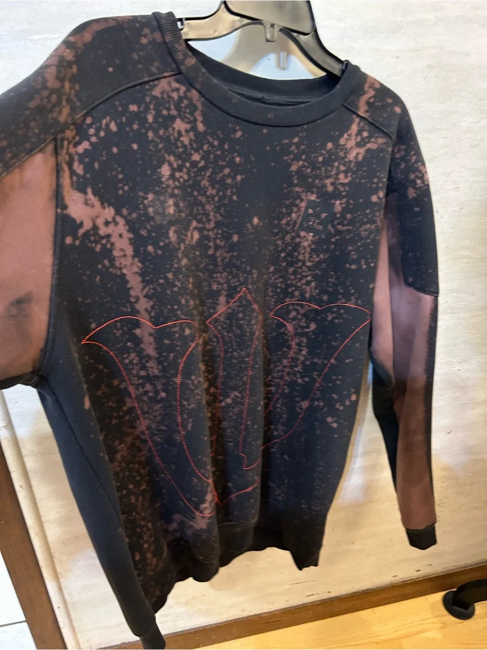 A upcycled, custom bleach-splattered Adidas crewneck sweatshirt
